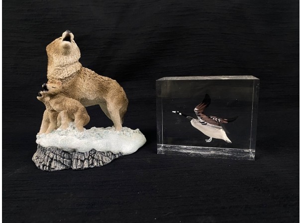 Carved wolf and pup figurine beside a goose in clear acrylic, featured items in this auction