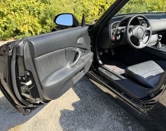 Open driver door and black leather seat of the S2000
