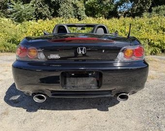 Rear of the black Honda S2000 with soft top up